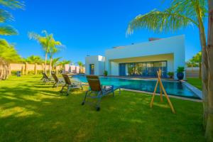 a group of chairs in a yard next to a swimming pool at Luxurious Marrakech Villa Pool, Hammam,Cinema in Marrakesh