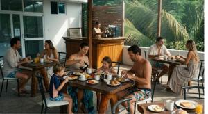 a group of people sitting at tables in a restaurant at Macedonia in San Clemente