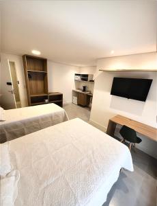 a hotel room with two beds and a flat screen tv at Premium Office-My Stay 09 in Brasília