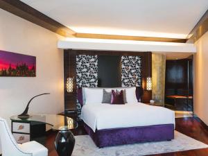 a bedroom with a large bed and a glass table at Sofitel Mumbai BKC in Mumbai