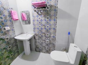 a bathroom with a toilet and a sink and a shower at Thano Retreat in Dehradun +7 photos
