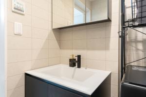 a bathroom with a white sink and a mirror at The Ichikawa House in Ichikawa +84 photos