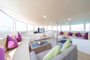 a large living room with purple and green pillows at Ocean Odyssey in Na Jomtien