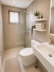 a bathroom with a toilet and a shower and a sink at Oasis 8 in Bacolod +25 photos