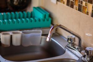 a kitchen sink with a faucet next to a green tray at Casa San Jerónimo in Puerto Escondido +32 photos