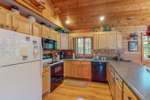 a kitchen with wooden cabinets and a white refrigerator at Ridge Wood in Empire +19 photos