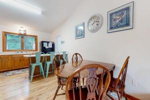 a dining room with a table and chairs and a clock on the wall at Dunes Trail in Glen Arbor