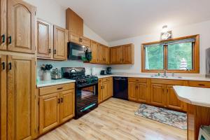 a kitchen with wooden cabinets and a stove top oven at Dunes Trail in Glen Arbor