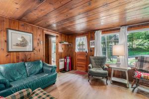 a living room with a green couch and a chair at Cottage Living in Beulah