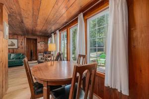 a dining room with a wooden table and some windows at Cottage Living in Beulah