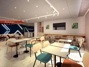 a restaurant with tables and chairs in a room at IBIS BUDGET GUINGAMP in Ploumagoar