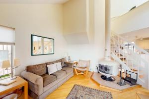 a living room with a couch and a staircase at Hawks Nest 58 in Glen Arbor