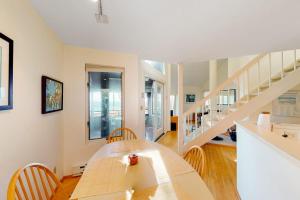 a dining room with a table and a staircase at Hawks Nest 58 in Glen Arbor