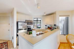 a kitchen with white cabinets and a counter top at Hawks Nest 58 in Glen Arbor +10 photos