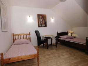 a room with two beds and a table and chairs at Agroturystyka pod Czarną Sosną in Biały Ług