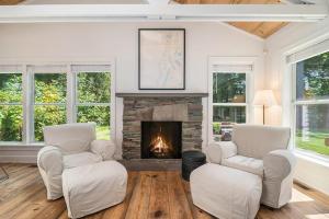 a living room with two chairs and a fireplace at White Pines Cottage in Glen Arbor