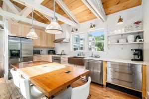 a kitchen with a wooden table and a large kitchen with stainless steel appliances at White Pines Cottage in Glen Arbor