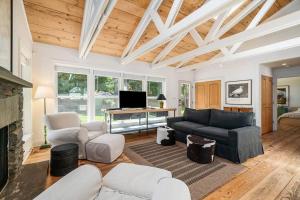 a living room with white furniture and a fireplace at White Pines Cottage in Glen Arbor