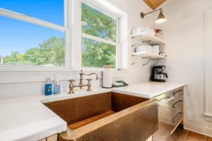 a kitchen with a sink and a window at White Pines Cottage in Glen Arbor +21 photos