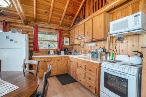 a kitchen with a stove and a refrigerator and a table at Cedar Crest in Empire +38 photos