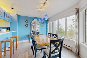 a dining room with blue walls and a table and chairs at South Beach 43 in Glen Arbor