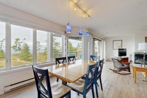 a dining room with a table and chairs and windows at South Beach 43 in Glen Arbor