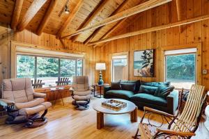 a living room with a green couch and chairs at Trout Lily Cabin in Beulah