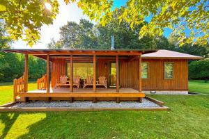 a wooden gazebo with a table and chairs at Trout Lily Cabin in Beulah