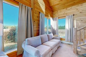 a living room with a couch and large windows at Green Pastures in Maple City