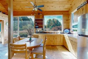 a kitchen with a table and a ceiling fan at Green Pastures in Maple City