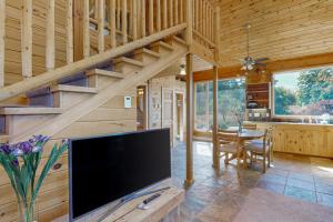 a living room with a large flat screen tv in a cabin at Green Pastures in Maple City