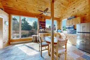 a kitchen with a table and chairs and a refrigerator at Green Pastures in Maple City
