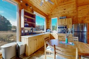 a kitchen with a table and a refrigerator at Green Pastures in Maple City +14 photos
