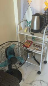 a table with a fan and a hat on a shelf at Emtri Apartments in Sipak