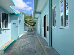 an empty alley between two blue buildings at Emtri Apartments in Sipak