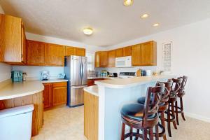a kitchen with wooden cabinets and a bar with stools at Northern Michigan Manistee Magic in Manistee