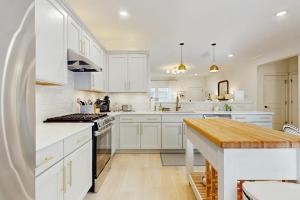 a white kitchen with white cabinets and a kitchen island at Wrightwood Cottage in South Haven