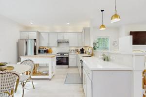 a kitchen with white cabinets and a table and chairs at Wrightwood Cottage in South Haven
