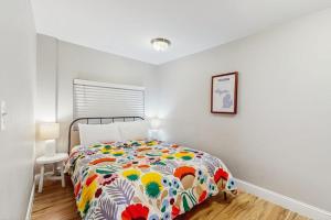 a bedroom with a bed with a colorful comforter at Arrowhead Resort - Stylish Retro Escape in Saugatuck +7 photos