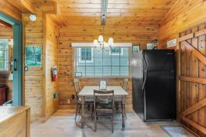 a dining room with a table and a refrigerator at Peterson Mill in Saugatuck
