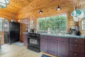 a kitchen with purple cabinets and a black refrigerator at Peterson Mill in Saugatuck