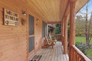 a porch of a wooden house with a bench at Kingfisher Cove Cabin 2 in Saugatuck