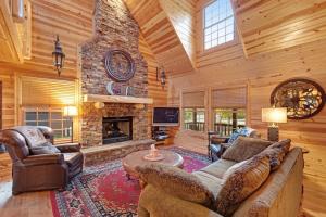 a living room with a stone fireplace in a log cabin at Kingfisher Cove Cabin 2 in Saugatuck +29 photos