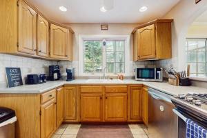 a kitchen with wooden cabinets and a sink at Wine Down Cottage in Union Pier