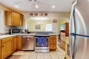 a kitchen with stainless steel appliances and wooden cabinets at Wine Down Cottage in Union Pier +17 photos