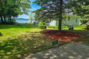 a yard with a tree and a sign in the grass at Kaap Kottage in Honor