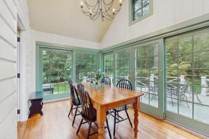 a dining room with a wooden table and chairs at Chalet May in Michiana