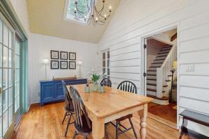 a dining room with a wooden table and a staircase at Chalet May in Michiana +19 photos