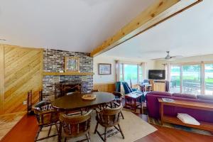 a living room with a table and a fireplace at The Summer House in Onekama