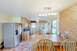 a large kitchen with a table and a refrigerator at The Summer House in Onekama